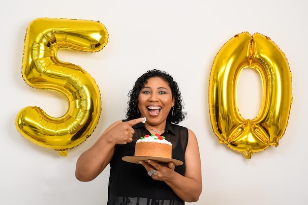 Foto la donna tiene una torta che celebra il compleanno, palloncino dorato numero 50