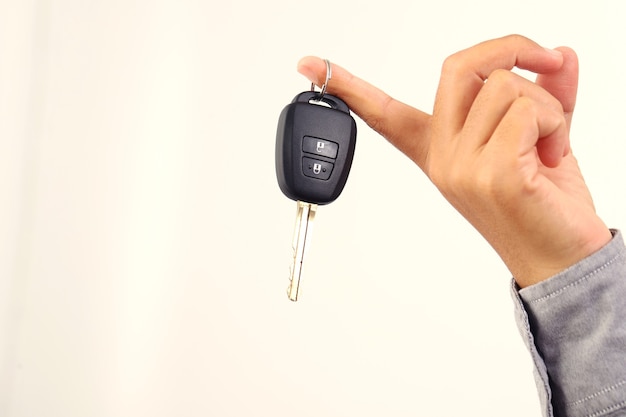 A woman holds a car key to show to a friend.