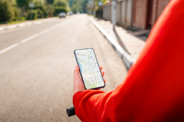 Photo a woman holds a cellphone with an online map app