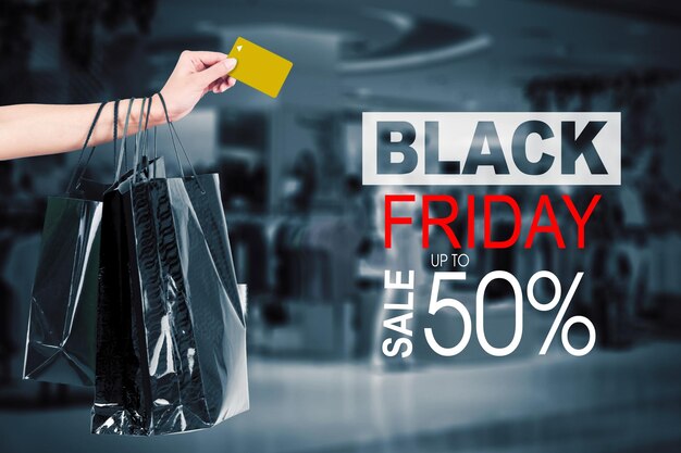 Foto la donna tiene la carta di credito con il testo di vendita del black friday