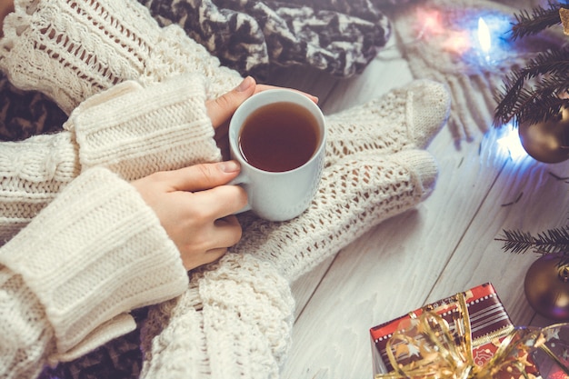 Woman holds a cup of tea beside her legs