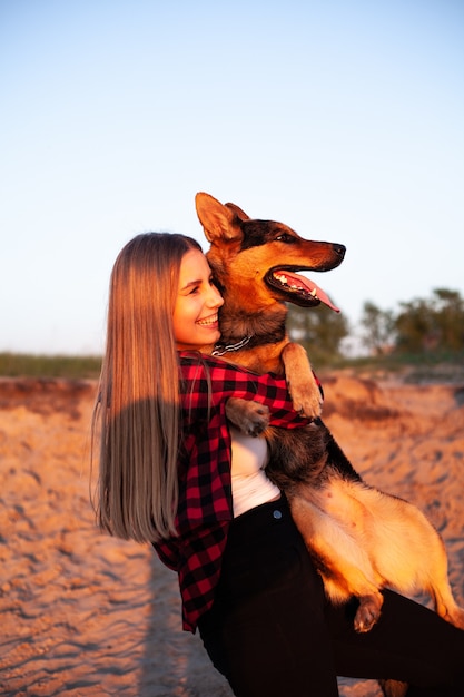 女性は彼女の腕に犬を抱きます。