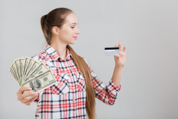 Женщина держит долларовые купюры и пластиковую карту