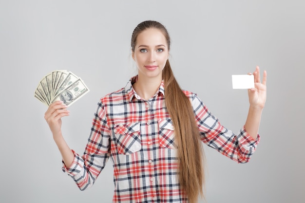 Woman holds dollar bills and plastic card