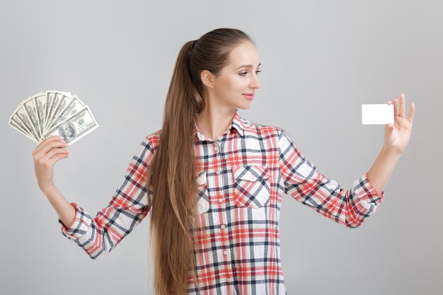 Photo woman holds dollar bills and plastic card