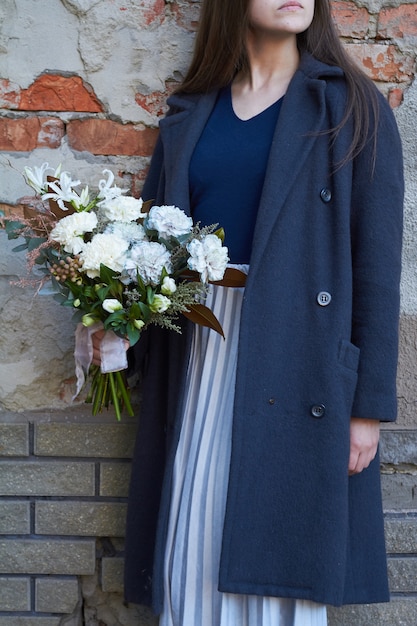 Woman holds floral bouquet outdoors