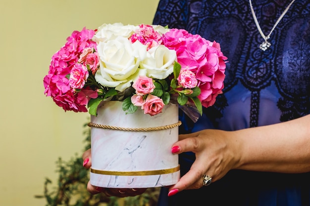 A woman holds a flower bouquet in her hands