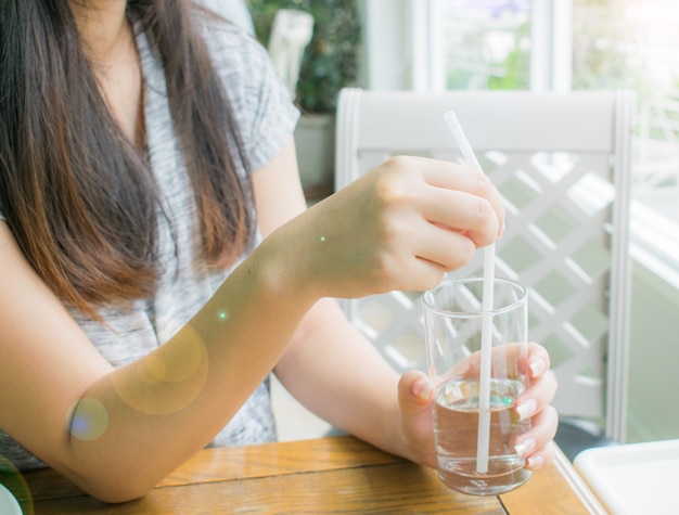 女性は一杯の水を保持します。