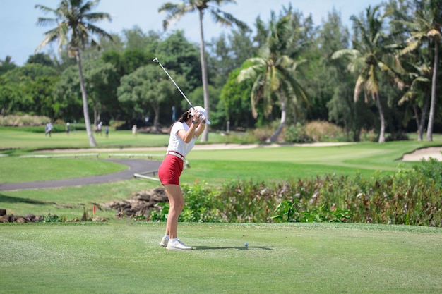 Woman holds golf club behind her back