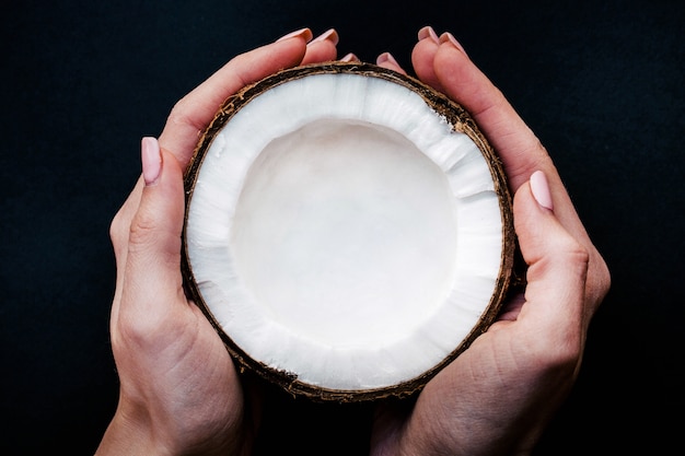 Woman holds half of a coconut