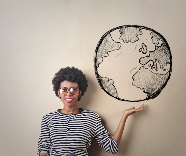 woman holds in her hand a drawing of a world