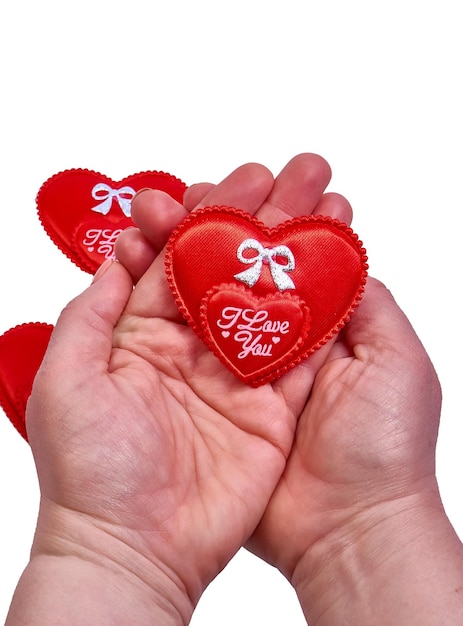 A woman holds in her hands a decorative red heart with the inscription I love you on a white background