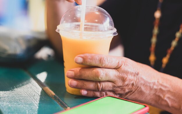 Woman holds in her hands a delicious and healthy smoothie with orange papaya and maracuja peach