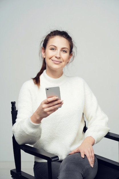 The woman holds in her hands the phone writes the message to\
the messenger for his