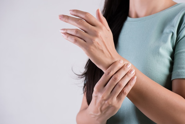 Woman holds her wrist hand injury, feeling pain. 