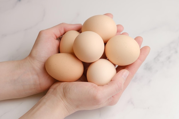 Woman holds large chicken eggs in her palms Farm chicken eggs