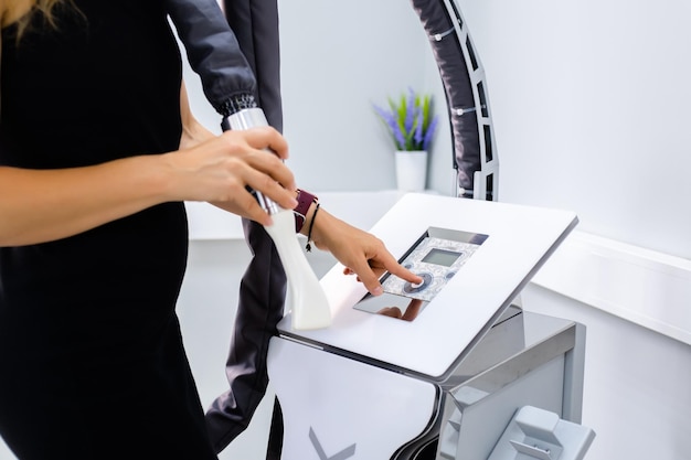 Woman holds manipulator of apparatus anticellulite LPG massage cosmetologist prepare for LPG massage session