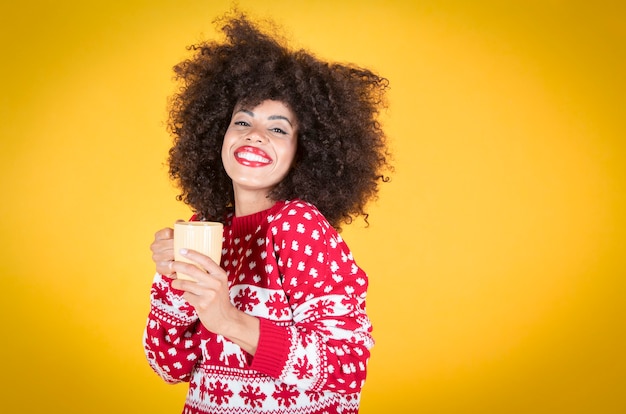 La donna tiene una tazza a natale, sfondo giallo