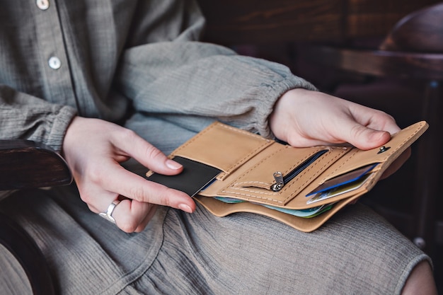 The woman holds an open wallet