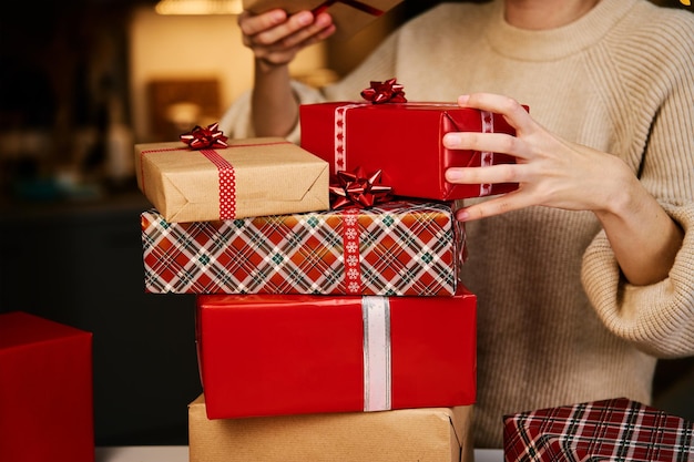 Женщина держит кучу подарков в подарочной коробке
