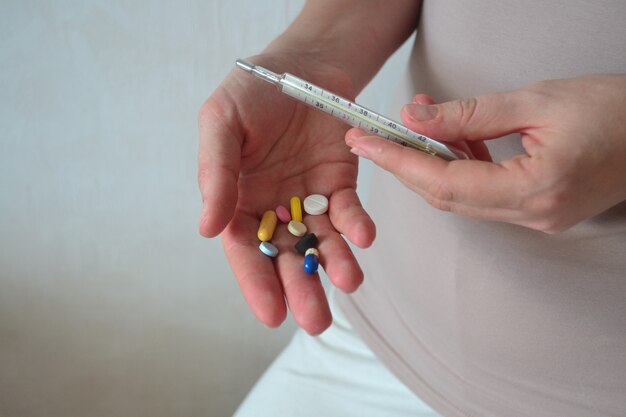 A woman holds pills and vitamins in her hands