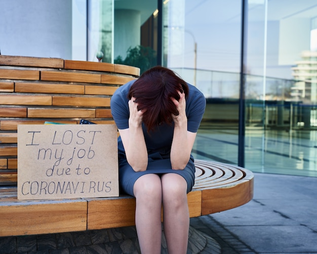 Woman holds sign about job loss