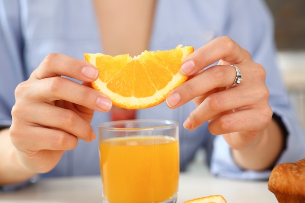 Photo woman holds a slice of sliced orange