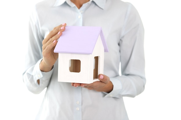 Woman holds small wooden house in hands real estate insurance concept