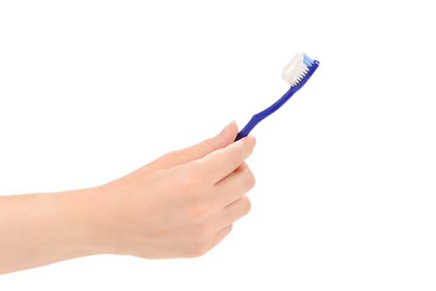 Woman holds toothbrush with toothpaste in her hand isolated on white