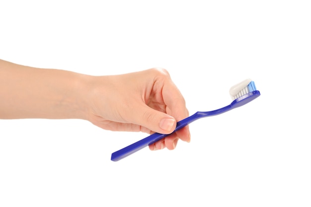 Woman holds toothbrush with toothpaste in her hand isolated on white.