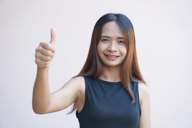 Woman holds up her thumb as a sign of excellence