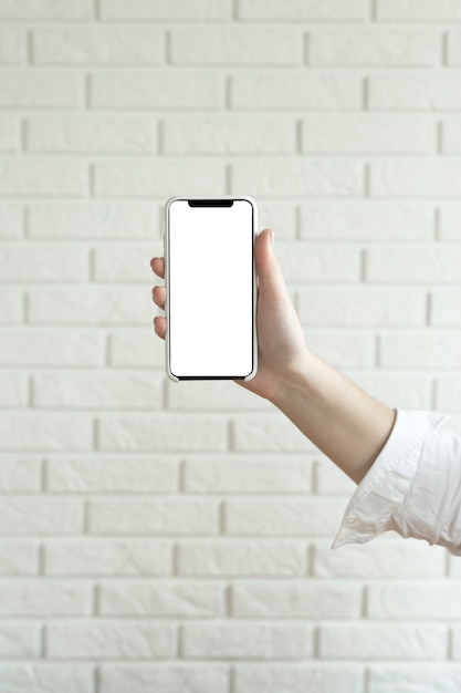 Woman holds and uses smartphone with a blank white screen