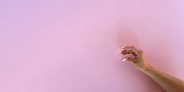 A woman holds a vaginal ring in her hands for contraception purposes