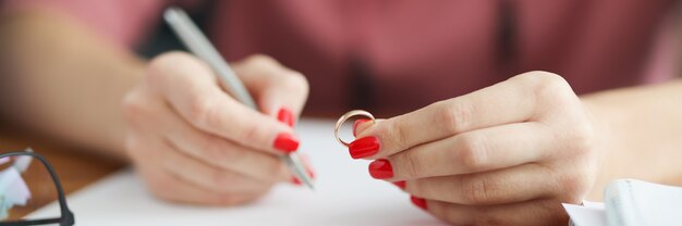 女性は結婚指輪を持って声明を書く