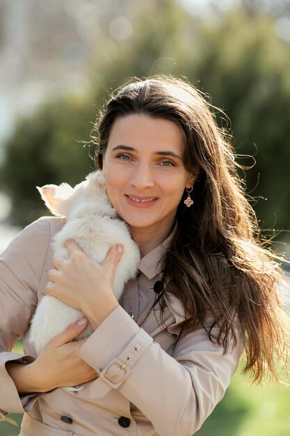 a woman holds a white puppy