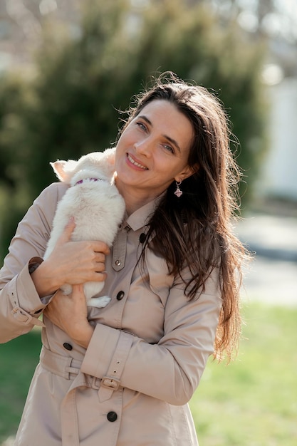 a woman holds a white puppy