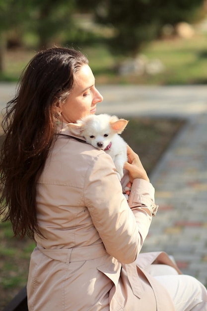 a woman holds a white puppy