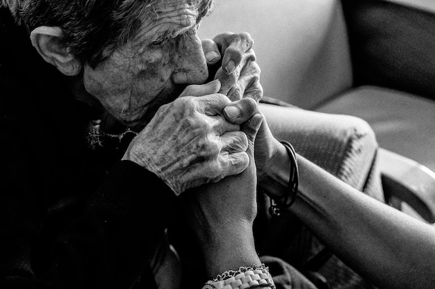 A woman holds a woman's hand in a black and white photo.