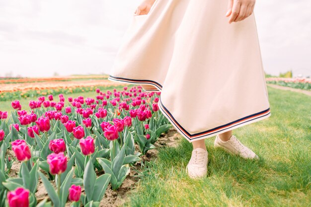 女性の休日の日は路地のチューリップに沿って行く