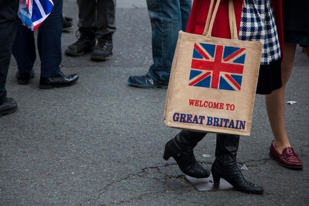 A woman holing a welcome to great britain shopping bag