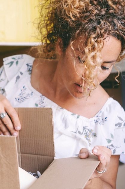 Foto donna a casa che fa scatole dopo un trasloco mutuo ipotecario affittare un nuovo concetto di appartamento cliente immobiliare casa piuttosto carina proprietario di persone nuova vita e cambiamento signora felice scatola di cartone aperta