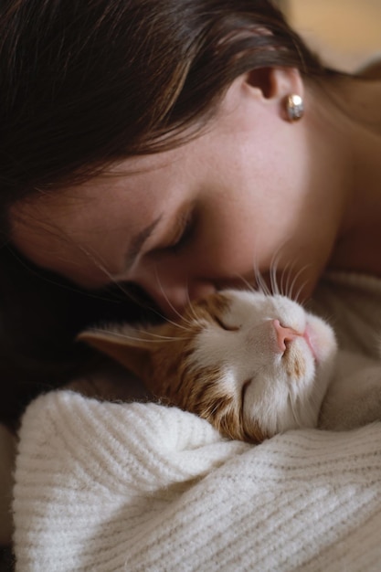 Woman at home holding her cat room interior on the bed