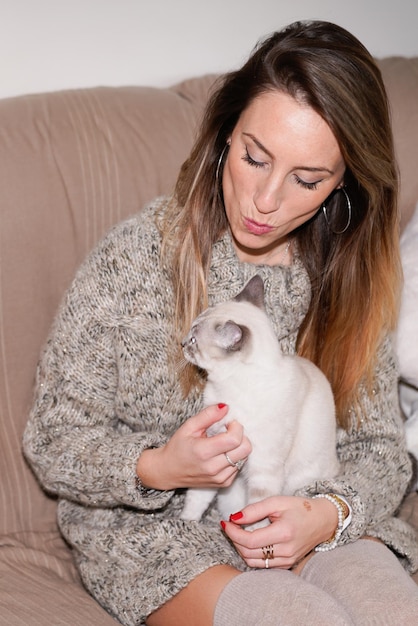 Woman at home with siamese cat