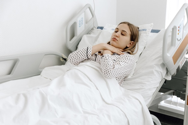 A woman hospitalized young woman lying in a hospital bed\
medicine and healthcare concept