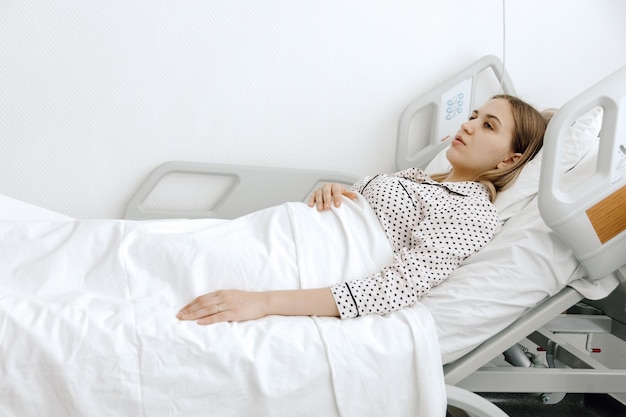 A woman hospitalized young woman lying in a hospital bed\
medicine and healthcare concept