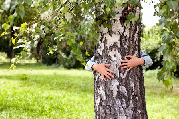 Woman hugging a big tree in a park