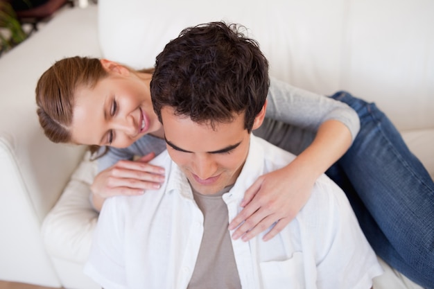 Woman hugging her boyfriend on the couch