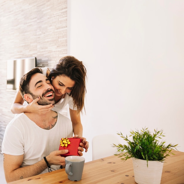 Woman hugging man while giving present