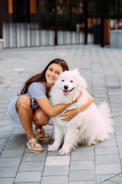 Woman hugs a big dog at sunset