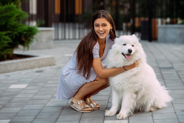 Woman hugs a big dog at sunset